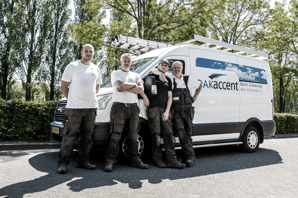 Team van dakdekkers leunt tegen een bestelwagen met de naam en logo van hun bedrijf.