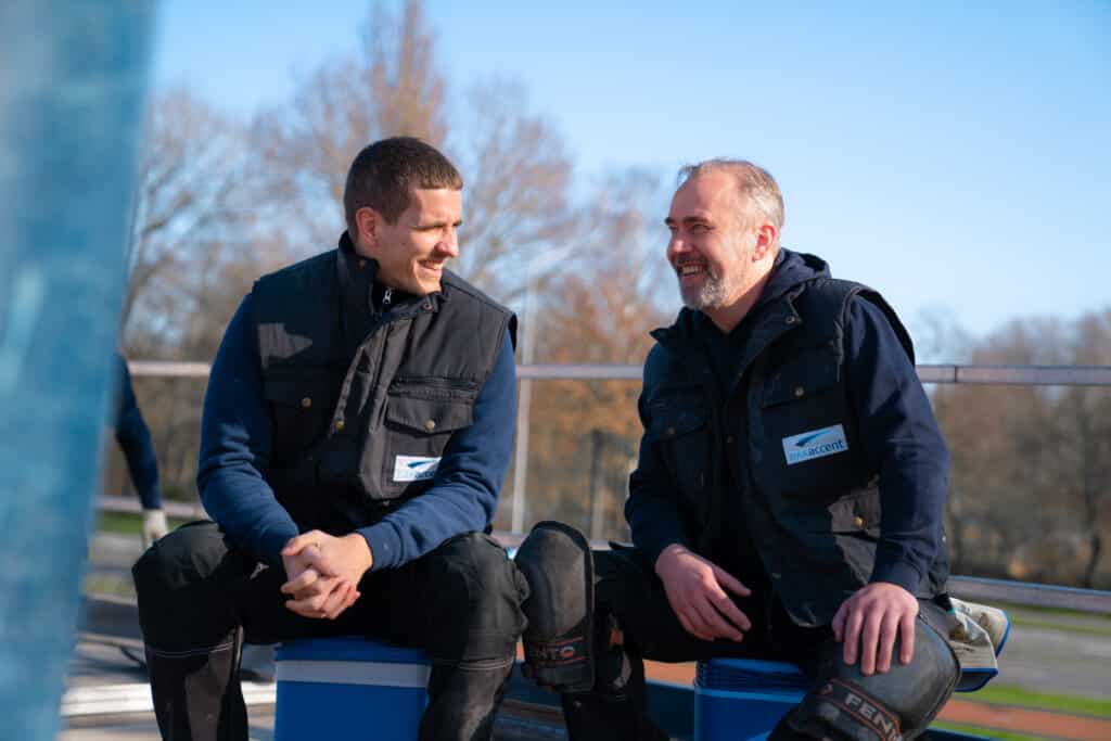 DAKaccent medewerkers ontspannen en voeren gesprek tijdens pauze op dak